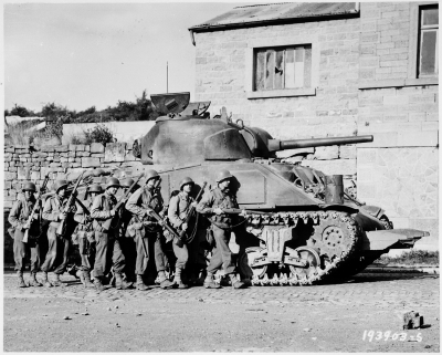 Yanks_of_60th_Infantry_Regiment_advance_into_a_Belgian_town_under_the_protection_of_a_heavy_tank._-_NARA_-_531213