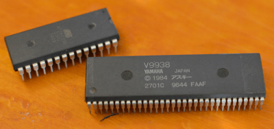 An SDIP-64 chip compared to a DIP-28 chip. Note the finer lead spacing on the SDIP device.