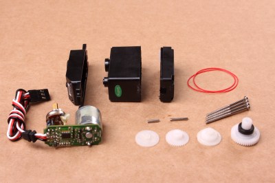 A disassembled servo motor showing the controller, motor, rotary encoder and gears. By oomlout - SERV-05-ST_TEARDOWN_03, CC BY-SA 2.0