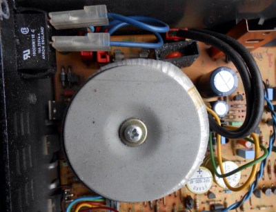 Mains power going straight into a toroidal transformer in set-top box from the late 1980s. The fuse and filter parts above the transformer are live, the rest of the board is relatively safe.