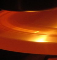 Visible-light photo of a rotating anode during exposure; note the bright focal point and overall heating of anode. Source: Rolf Behling