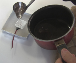 Pouring melted wax into a capacitor mold