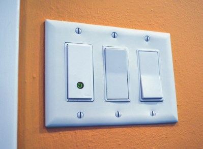WeMo WiFi light switch to the left of two "dumb" switches
