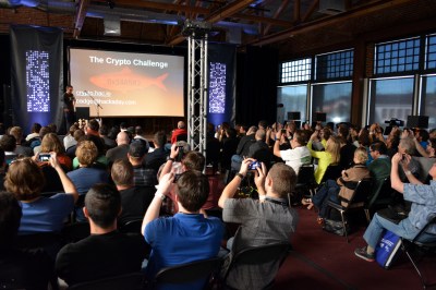 Everyone in the room taking pictures of Brian Benchoff's literal red herring during Crypto challenge unveiling