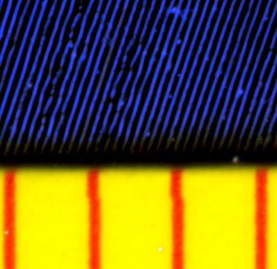 Close-up magnification of a 45RPM vinyl record, showing the audio waveform in each groove. The red lines are 1mm apart. Alex:D [Public domain], via Wikimedia Commons.