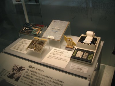 Busicom calculator motherboard based on 4004 (center) and the calculator (right)