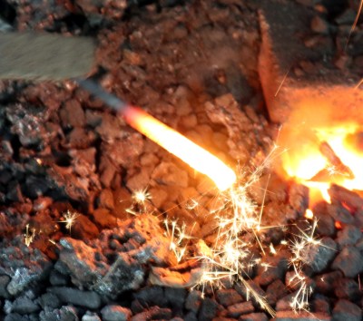 This piece of steel has been left in the fire too long, and is burning like a sparkler.