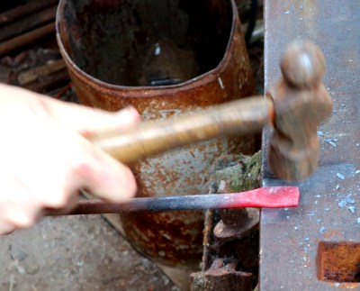 Hammering a flat on the end of a piece of bar stock. Mine has by good fortune remained consistent, but don't worry if yours has a slightly oval shape.