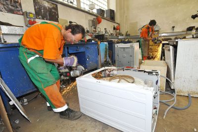 Czech waste management workers dismantle scrap washing machines. Tormale [CC BY-SA 3.0].