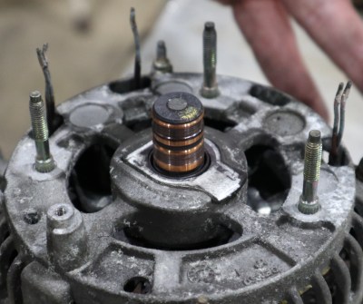 The rear plate of the alternator with the regulator and rectifier removed, showing the stator winding connections.