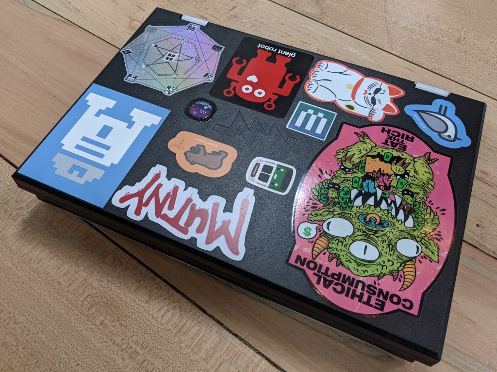 the top of a laptop covered in stickers