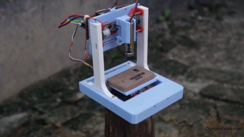 A 3D-printed mini laser engraver made from DVD-RW drive motors.