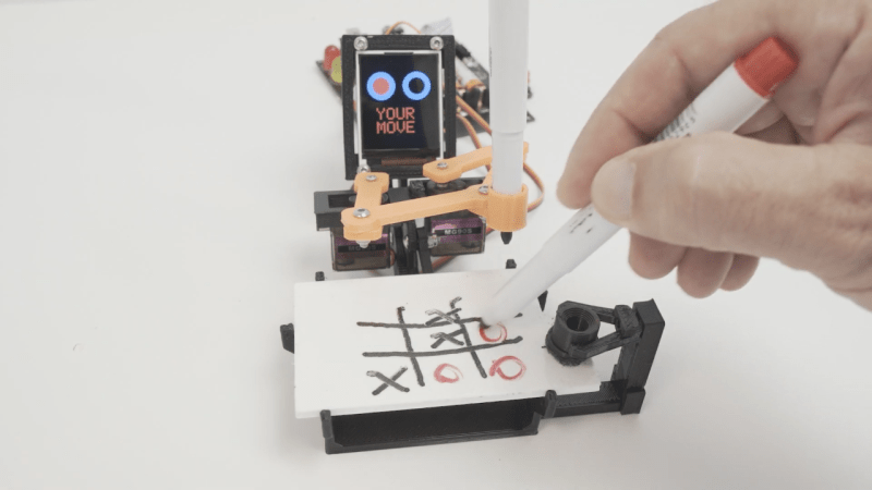 A robot playing tic-tac-toe against a human