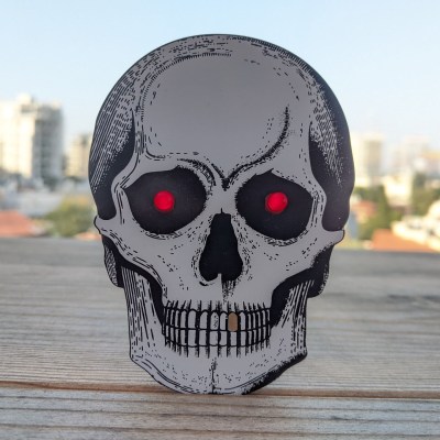 A skull-shaped PCB with two red eyes