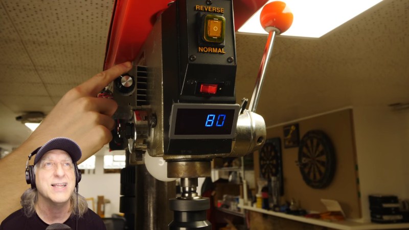 Drill press modded with a treadmill motor, speed controller, lights, and a tachometer.