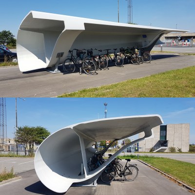 A picture of a wind turbine blade that has been turned into a bike shed.