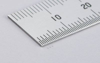 A ruler with three very small capacitors next to it
