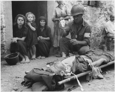 Private Roy W. Humphrey of Toledo, Ohio is being given blood plasma after he was wounded by shrapnel in Sicily on August 9th, 1943
