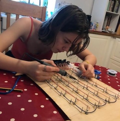 Soldering up a bunch of LEDs to nails, old school style.