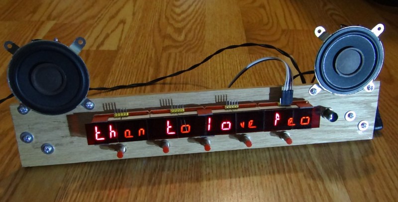 A wooden device with an LED display and speakers