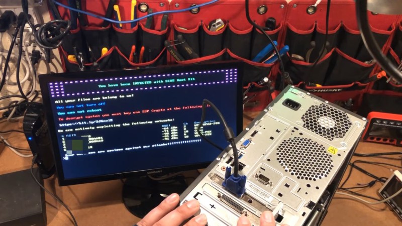 Picture of a monitor with a fake "ransomware" banner on it, and a PC with the ESP32 VGA devboard mounted into it in the foreground