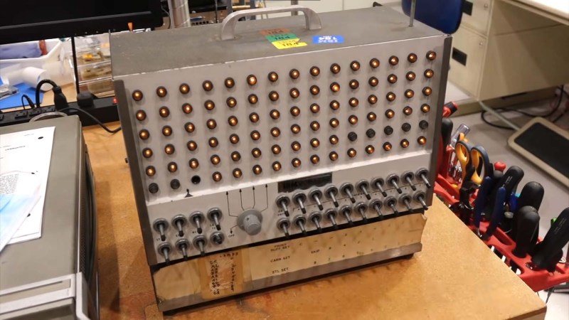 A briefcase sized electronic machine with many indicator lamps and switches