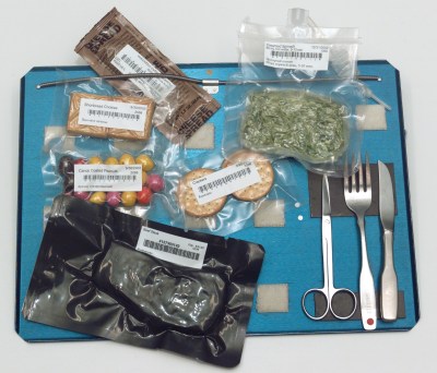 A tray of space foods complete with magnet, springs, and Velcro to hold things in place.