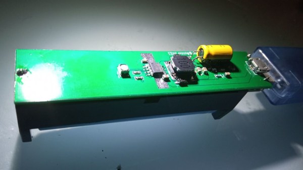 The powerbank PCB, with all the components on one side, 18650 holder on the other, a MicroUSB cable plugged into the PCB's MicroUSB socket