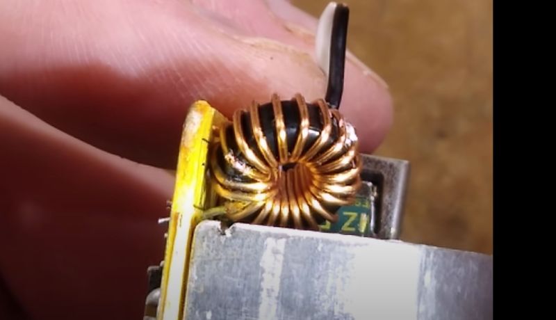 Pre-exploded PSU close-up: shown is inductor with the heatsink it shorted against.
