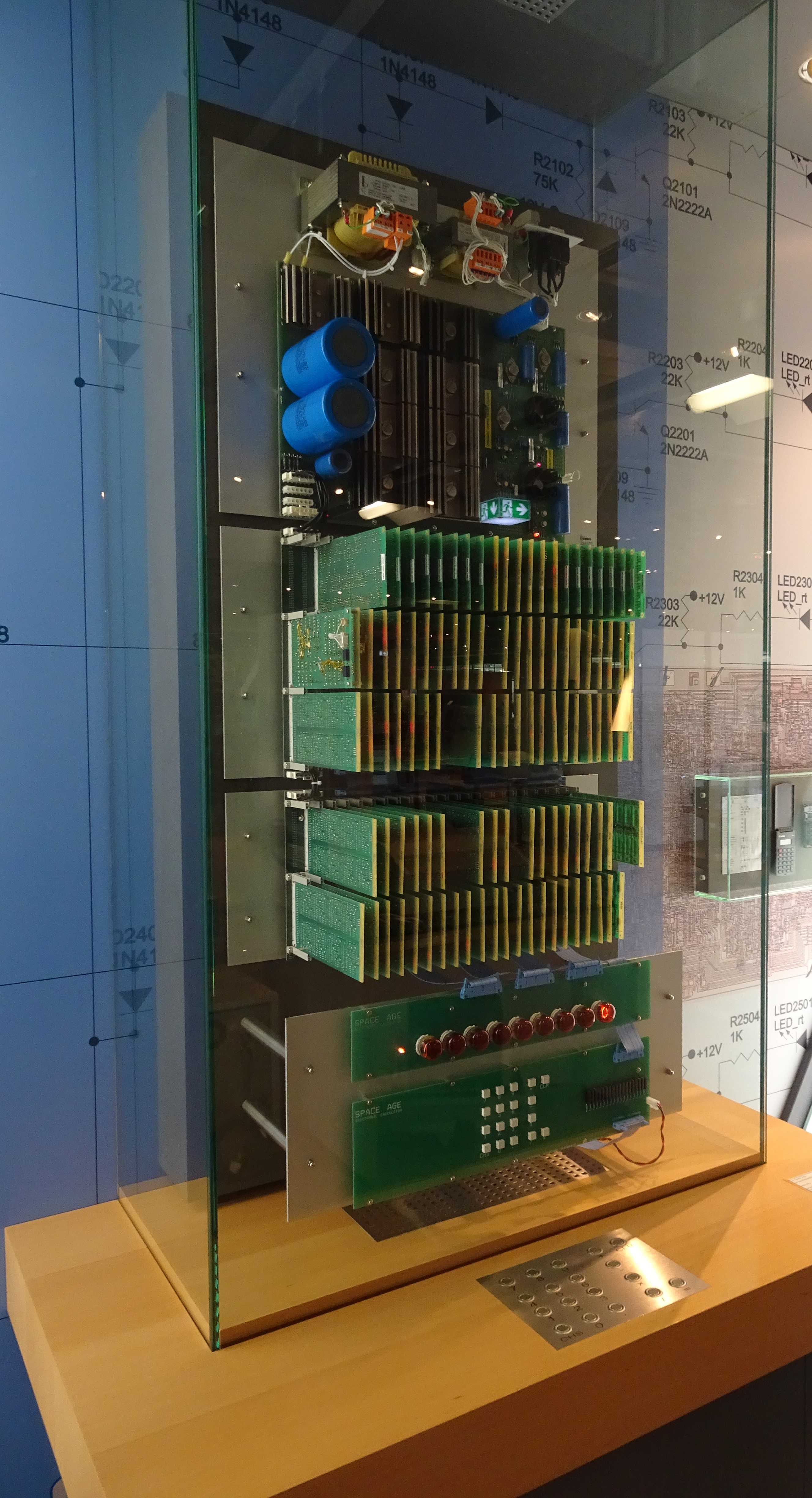 A calculator made of many circuit boards in a glass display case