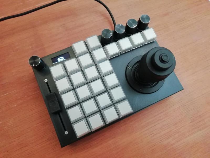 An input device combining a joystick with several knnobs and buttons