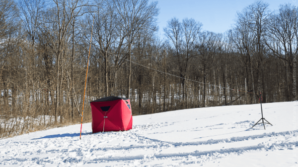 ice fishing tent and antenna in a snowy field