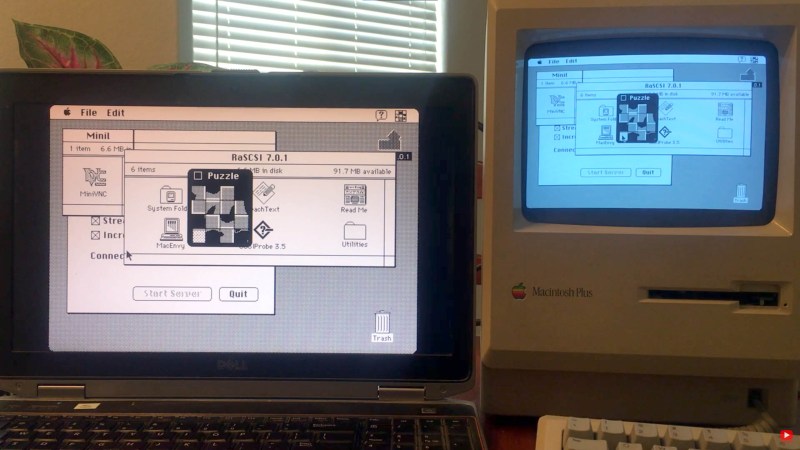 A Macintosh Plus computer next to a modern laptop