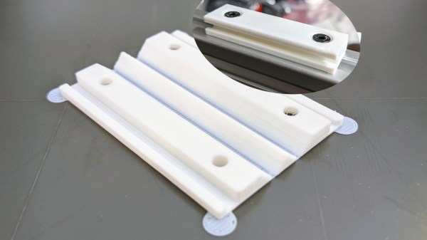 The eurorack rail piece, just printed in white plastic, not yet folded, with a folded example in the upper right corner