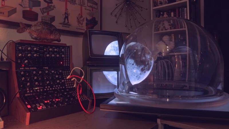 Moon moving from inside a large glass sphere into screens of two vintage television sets