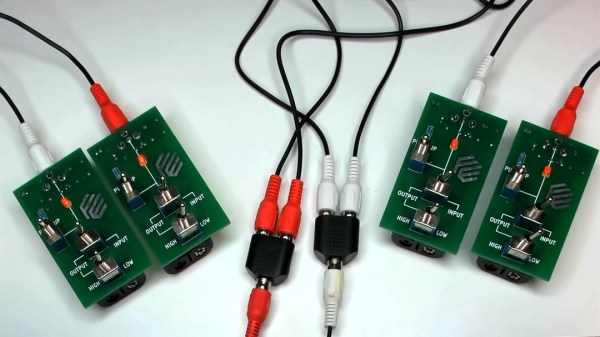 Two pairs of boards described in the article, with toggle switches and RCA jacks, shown interconnected, LEDs on all four boards lit up.