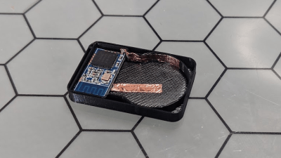 a NRF51822 module in a 3d-printed case, with a copper strip used for holding a CR2032 battery