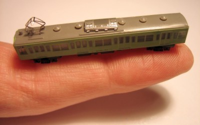 T scale electric locomotive held on a human finger