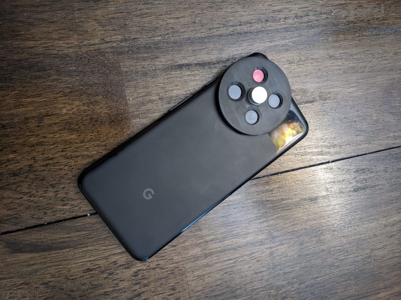 A Google Pixel 3a with a filter wheel attached to its camera