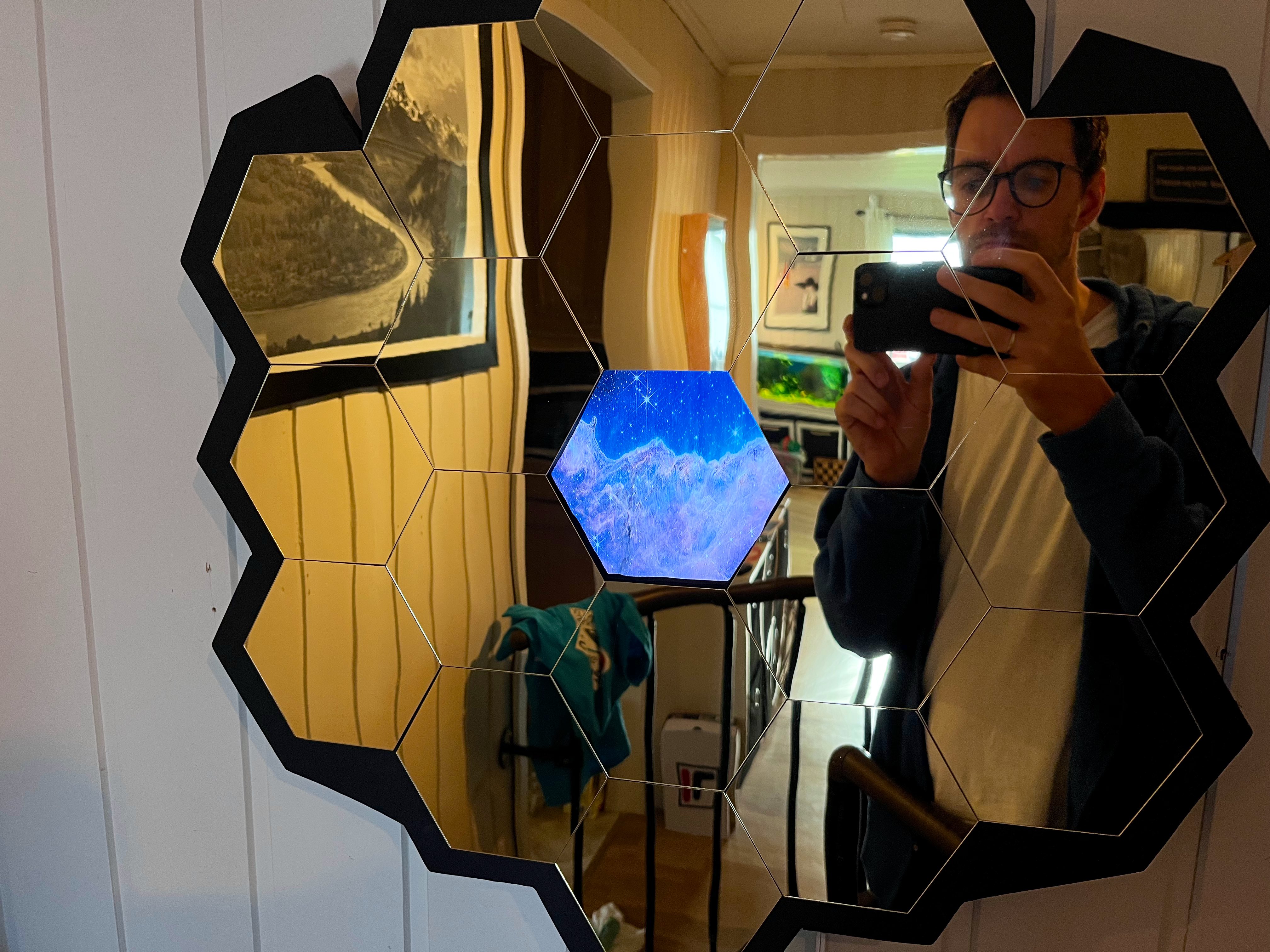 A wall-mounted display made from 18 golden hexagonal mirrors