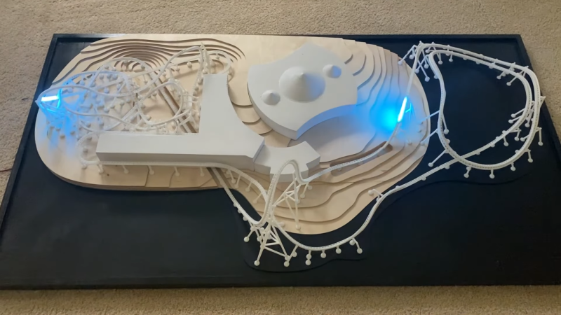 A 3D printed roller coaster model with light strips modelling the trains