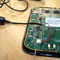 The tablet in question with back cover removed, battery wires connected to a USB cable for power