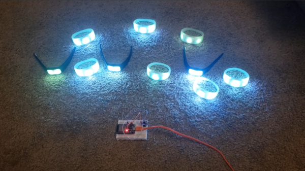 A family of PixMob bracelets being coltrolled by an ESP32 with an IR transmitter attached to it. All the bracelets are shining a blue-ish color