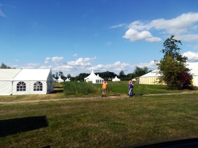 A field with a few tents and a blue sky