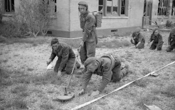 Sappers clearing the last mines from the beach front of a former French luxury hotel, now in use as a rest club for troops of 3rd Division, 15 July 1944.