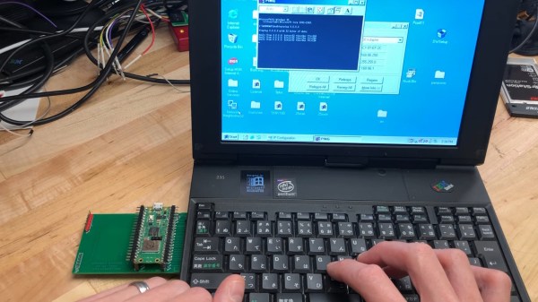 Card's author typing on the IBM PC110's keyboard, with the Pico W-based card plugged into the PCMCIA slot on the left. PC110's screen shows successful ping 8.8.8.8.8.