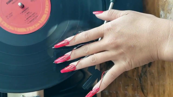 Glue-on nails with vinyl record pickups pierced through them that are used on a vinyl record