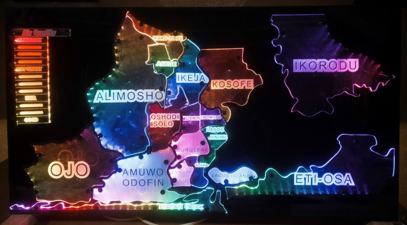 An acrylic map of the state of Lagos. Each region is lit a different color by LEDs shining on the acrylic panels. The colors coorespond to the air quality index key which is lit in cooresponding colors to the value.