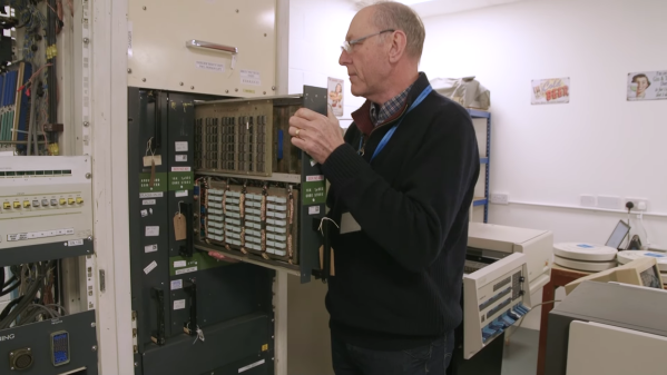 A man removing a module from a 1960s computer