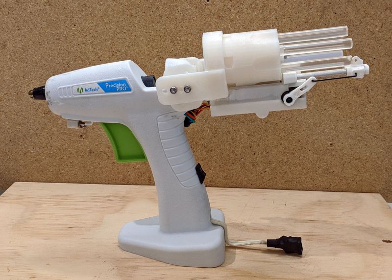 A hot glue gun with a revolving stick holder on the back